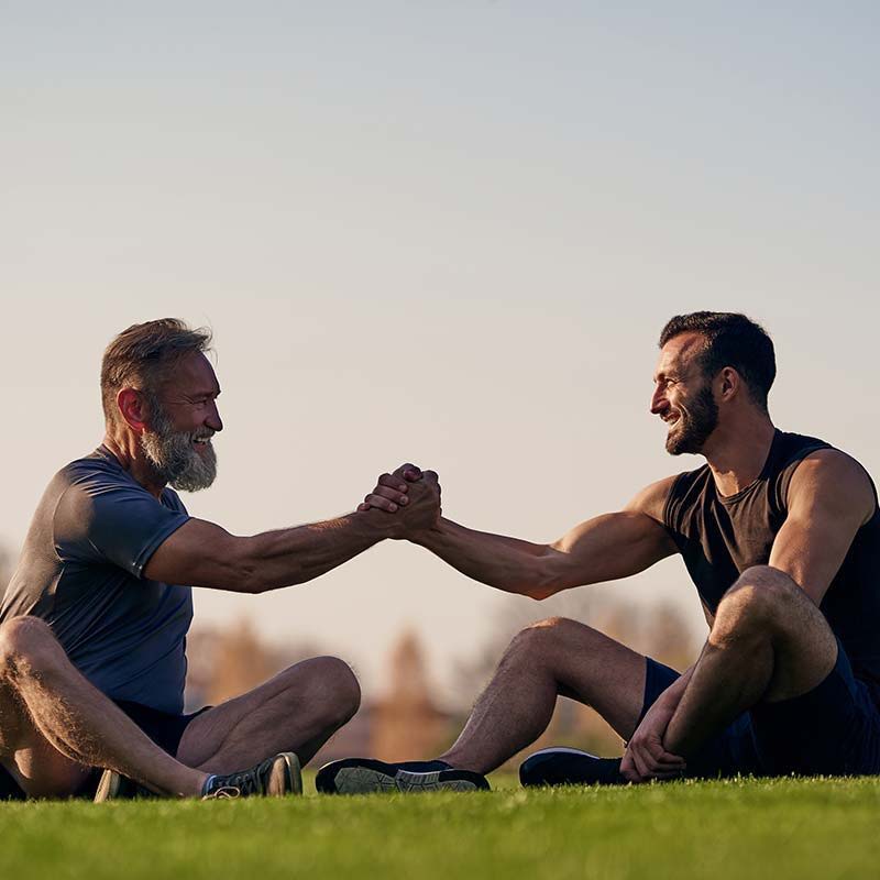 two guys sitting on the grass